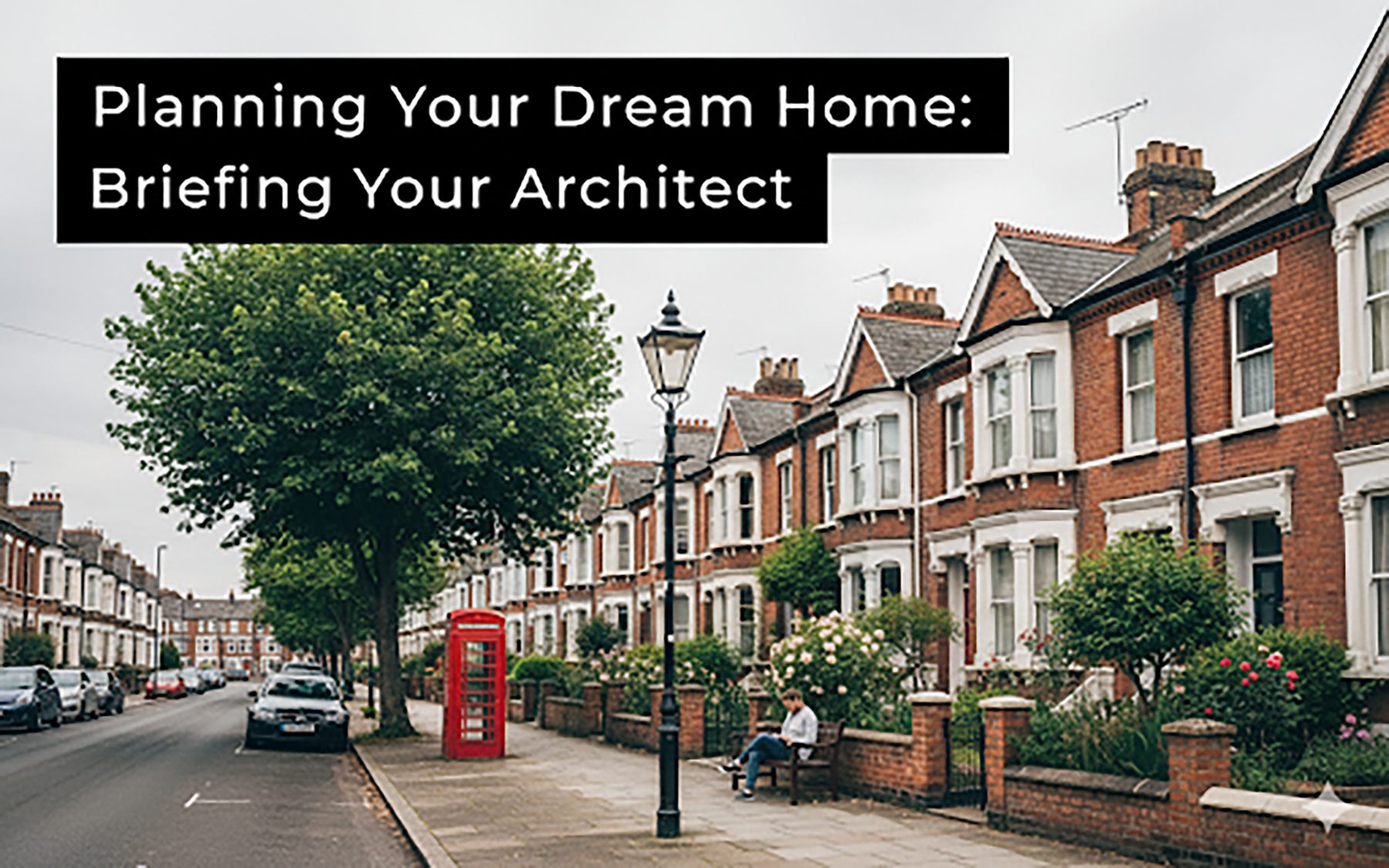 A tree-lined street of red brick Victorian terraced houses with bay windows, a street lamp and a red telephone box