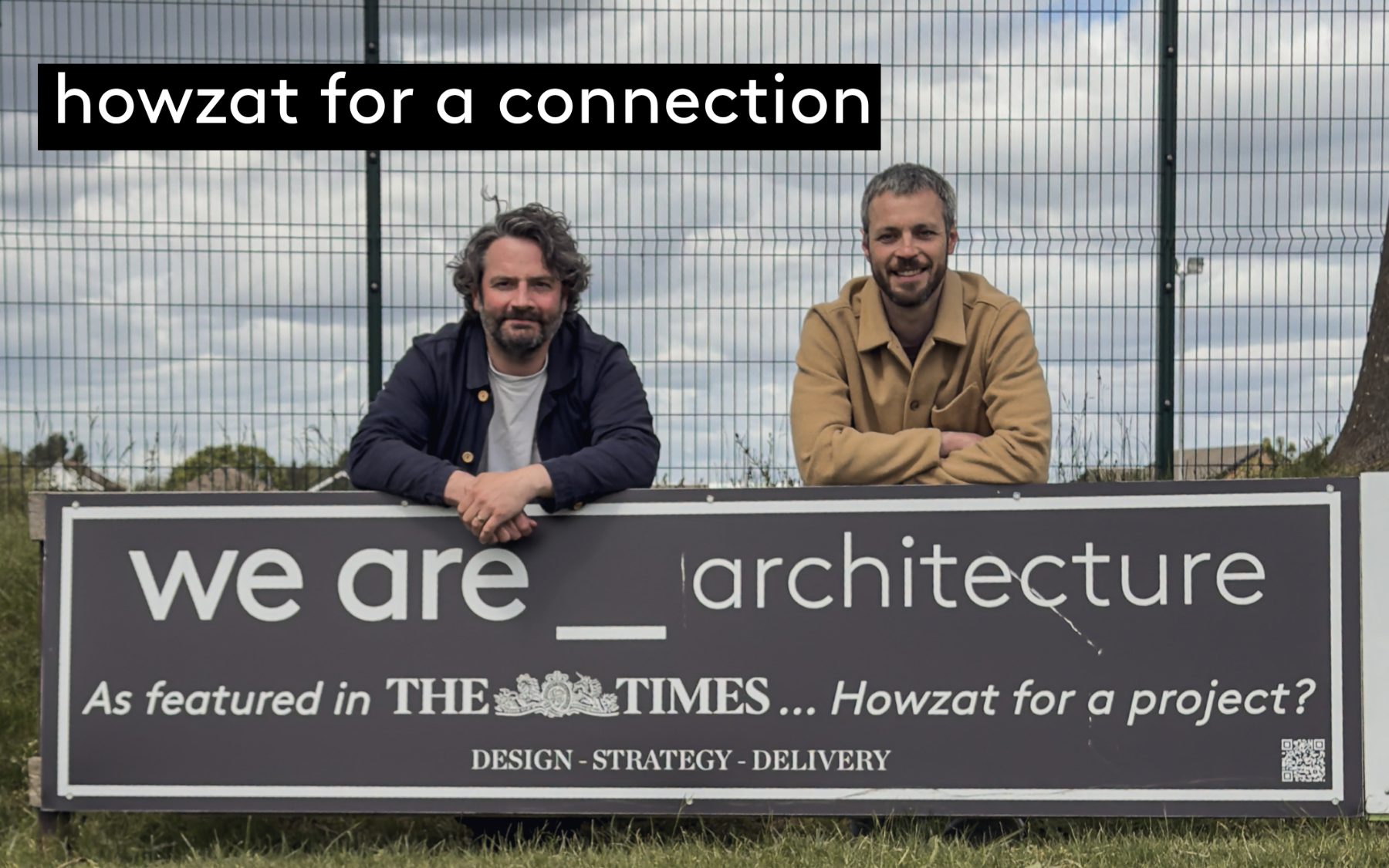 Andrew and Jack leaning on the we are _ architecture sponsor board at the edge of Morley Cricket Club’s ground